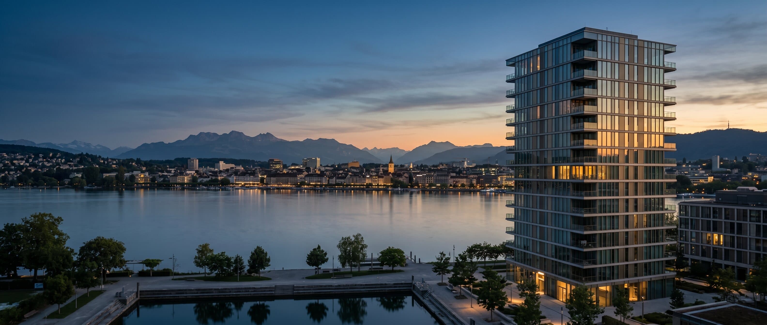 Moderner Glas-Wohnturm am See bei Dämmerung — Immobilien-Investment Schweiz